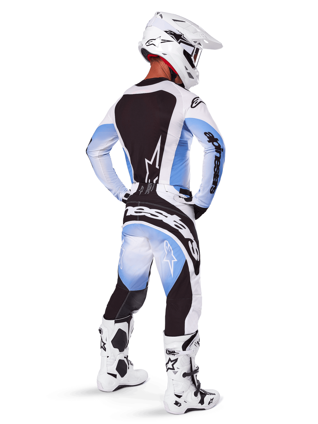 Pilote de motocross portant un équipement de course complet, ensemble Techstar Melt 2025, maillot blanc et bleu clair avec panneau arrière noir, pantalon assorti avec dégradé bleu et accents noirs, casque blanc, bottes blanches et noires, tenue coordonnée pour la course tout-terrain