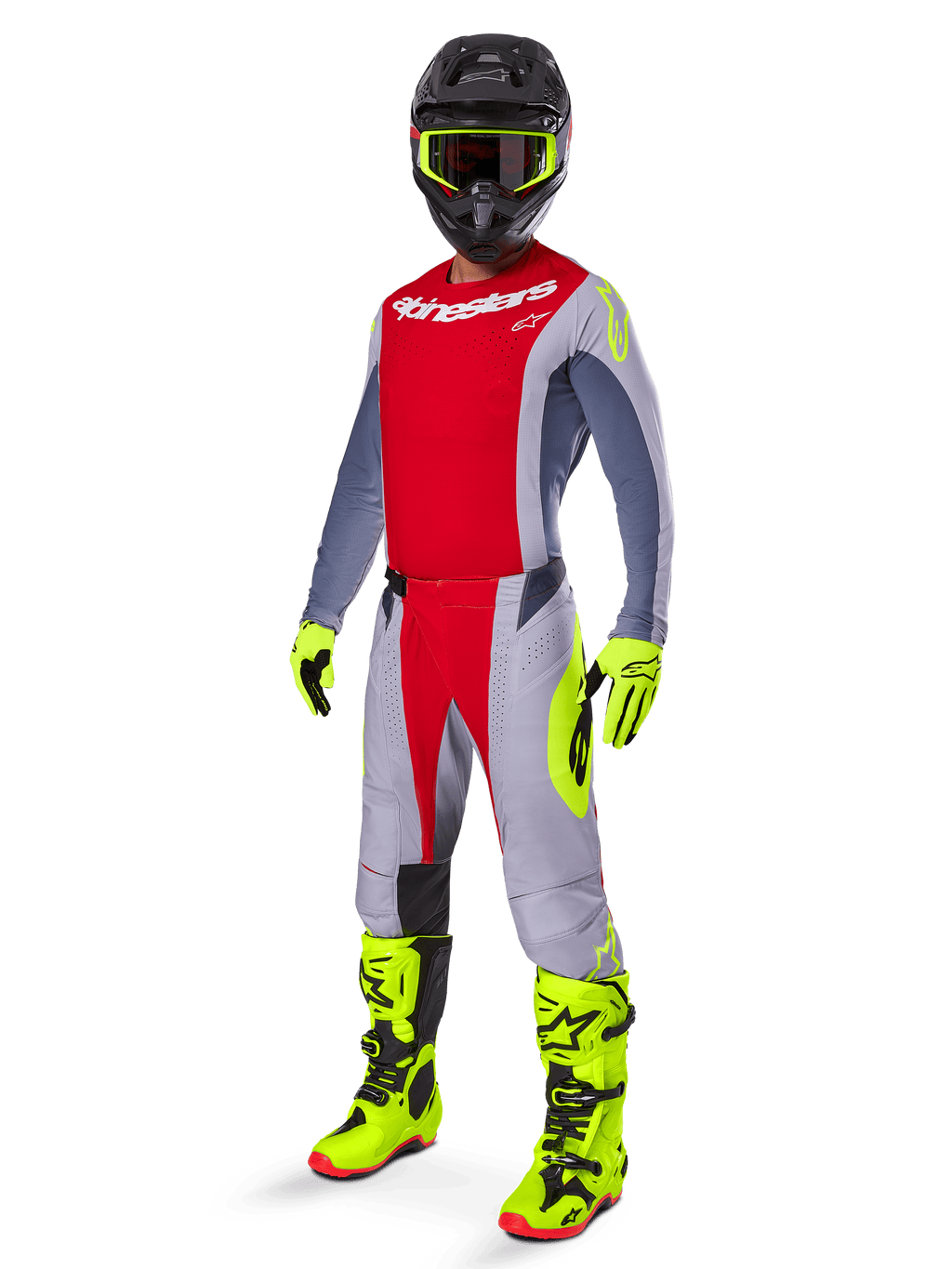 Pilote de motocross portant le maillot Alpinestars Techstar Melt 2025 rouge vif et gris, avec buste rouge et manches grises aux accents jaune fluo, assorti d'un pantalon coordonné, de bottes et gants jaune vif, et d'un casque noir avec lunettes à monture jaune pour une tenue de course tout-terrain complète.