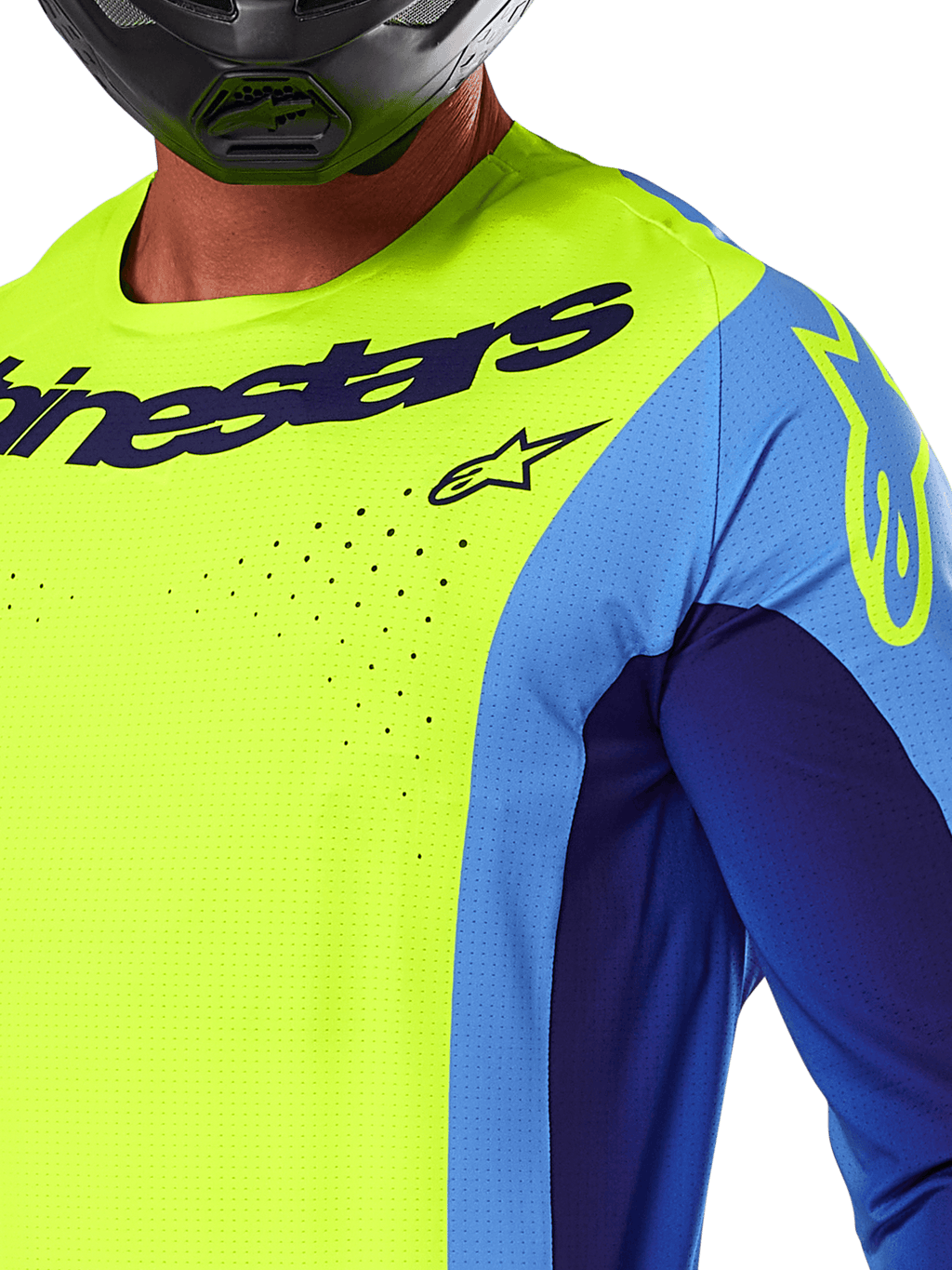 Maillot Alpinestars Techstar Melt 2025, maillot de motocross, jaune fluo et bleu, gros plan montrant les perforations de ventilation découpées au laser et le marquage bleu marine, porté par un pilote avec un casque noir, équipement de performance pour la course tout-terrain