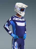 Alpinestars 2026 Racer Riway Ausrüstungsset, Motocross-Fahrer in marineblauem und hellblauem Trikot mit weißem 'astars'-Branding, passender marineblauer Hose mit weißen Akzenten, weißem Helm mit blauer Brille und blauen Handschuhen, komplette professionelle Ausrüstung für den Offroad-Rennsport