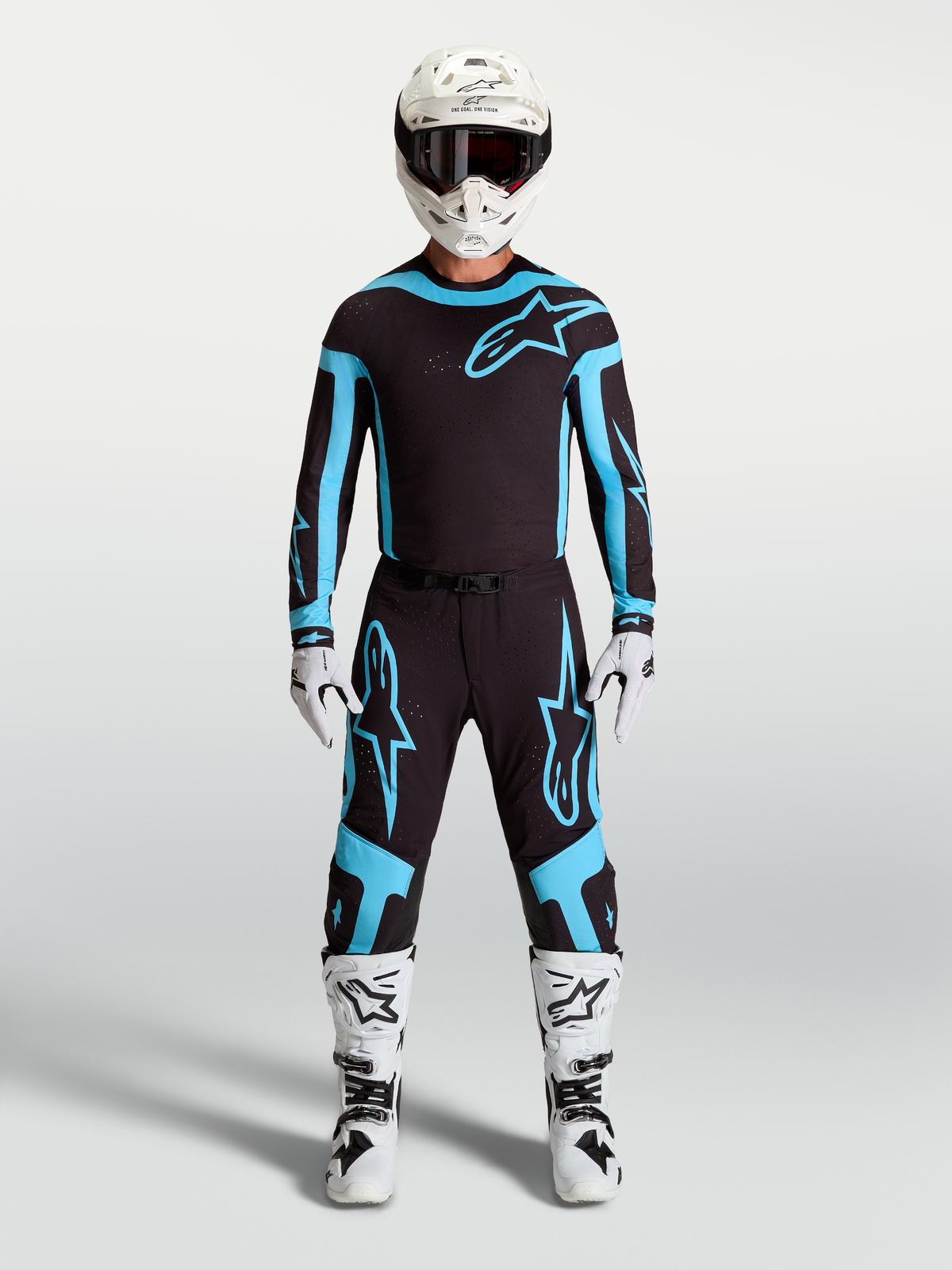 Alpinestars ensemble Supertech Vesta et maillot, tenue de motocross pour homme, noir et turquoise avec bottes et casque blancs, équipement de course tout-terrain.