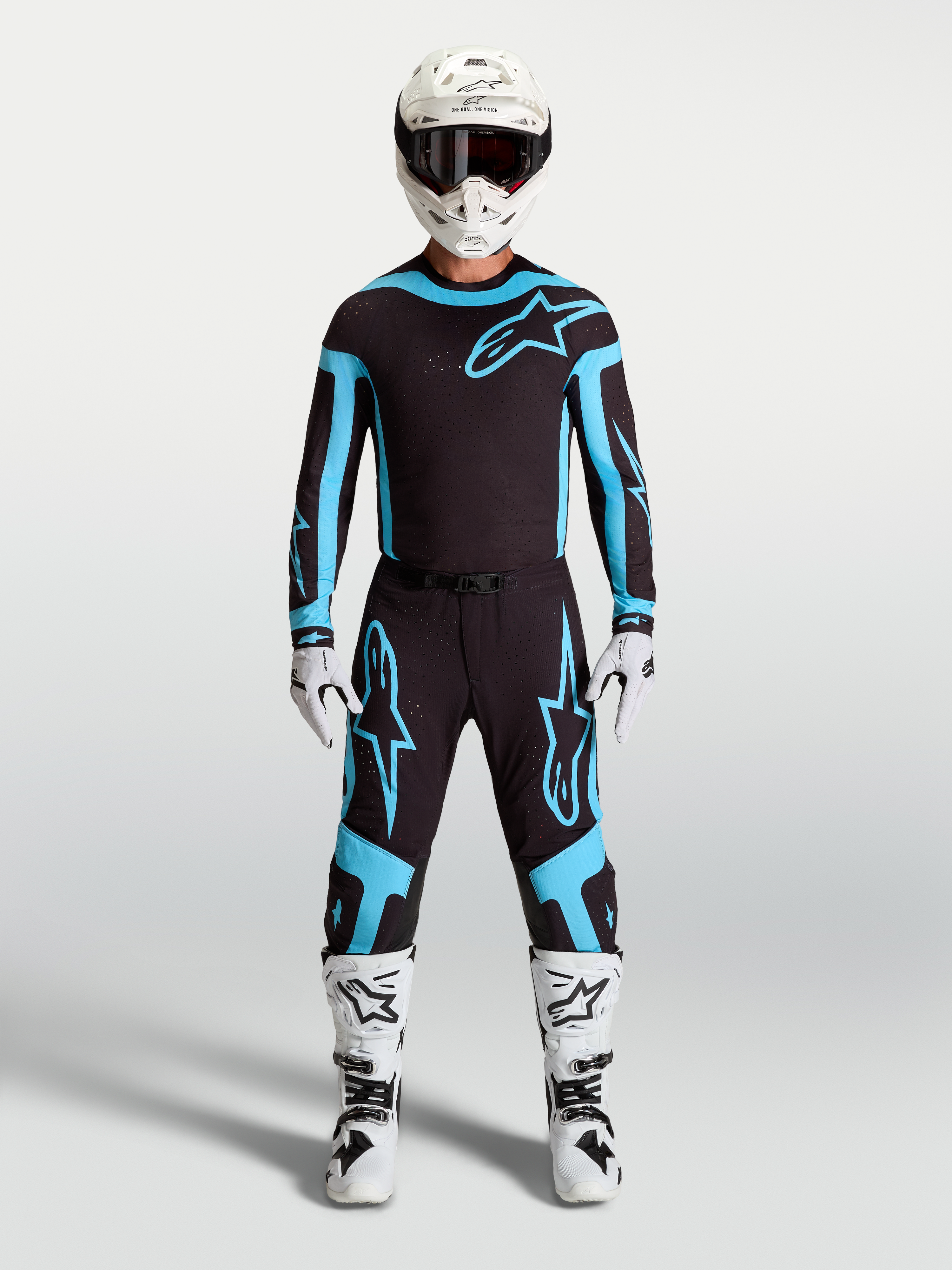 Alpinestars Supertech Vesta Trikot und Ausrüstungsset, Herren-Motocross-Outfit in Schwarz und Türkis, kombiniert mit weißen Stiefeln und Helm für professionelle Offroad-Performance.