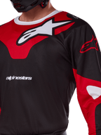 Alpinestars 2025 Racer Veil Jersey, motocross jersey, zwart en felrood, close-up met een groot wit Astars-logo op een rood borstpaneel, witte merktekst en technische vochtafvoerende stof.