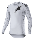Alpinestars 2023 Supertech North Jersey, Motocross-Jersey, Haze-Grau und Schwarz, weißes Langarm-Jersey mit grauem Fleckenmuster an den Ärmeln und Seiten, schwarzes Stern-Logo auf der Brust und den Schultern, Performance-Stretch-Mesh mit abgerundetem Saum