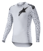 Alpinestars 2023 Supertech North Jersey, Motocross-Jersey, Haze-Grau und Schwarz, weißes Langarm-Jersey mit grauem Fleckenmuster an den Ärmeln und Seiten, schwarzes Stern-Logo auf der Brust und den Schultern, Performance-Stretch-Mesh mit abgerundetem Saum