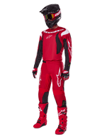 Motocross-Fahrer im Alpinestars 2025 Fluid Haul Gear Set, leuchtendes Rot mit schwarzen und weißen Akzenten, komplettes Outfit inklusive Trikot, Hose, Helm, Stiefeln und Handschuhen, entwickelt für Offroad-Performance und Schutz
