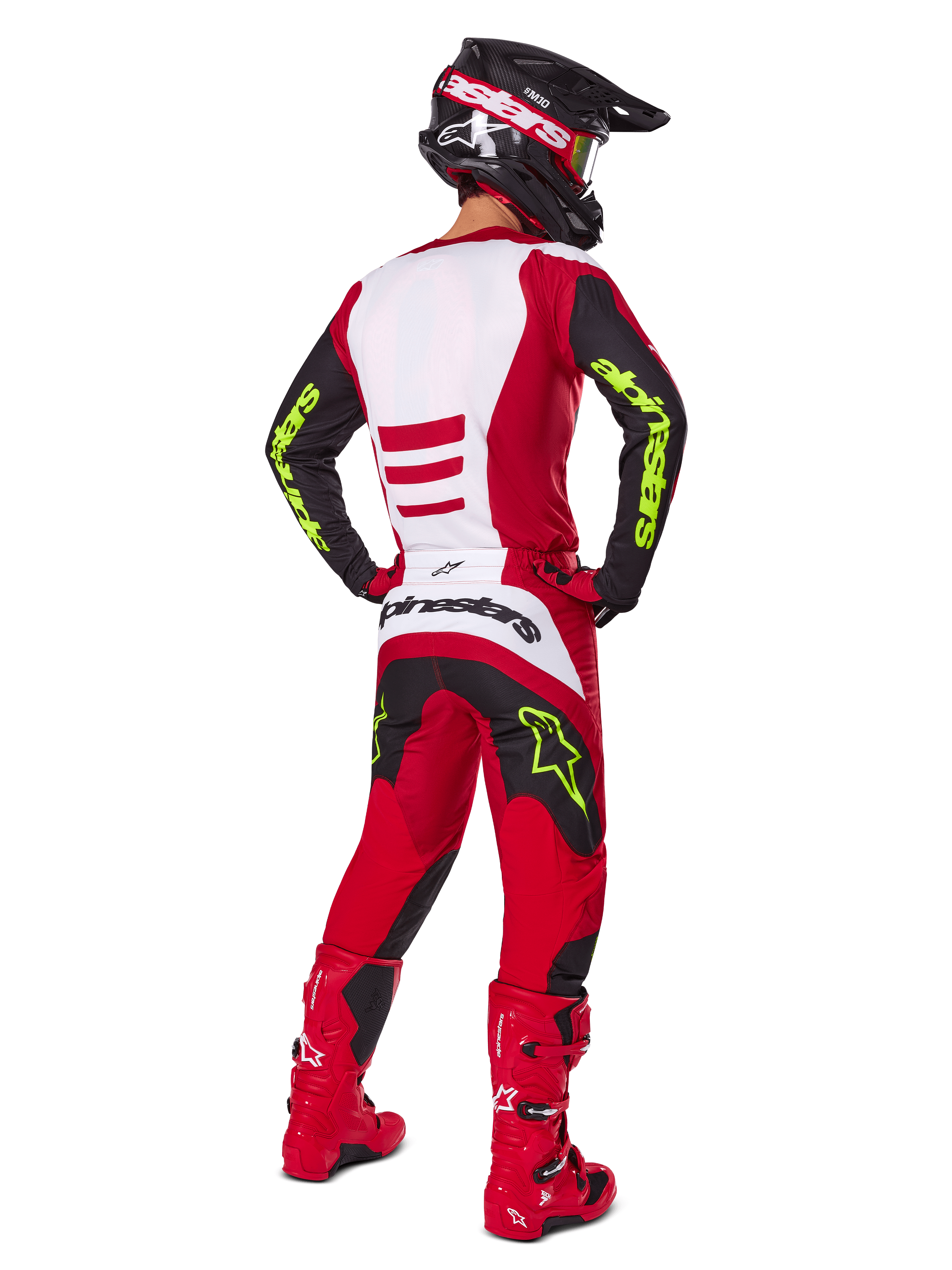 Motocross-Fahrer von hinten im Alpinestars 2025 Fluid Haul Gear Set, Hellrot und Schwarz mit weißen Einsätzen, neongelbes Branding auf Ärmeln und Hose, passende rote Stiefel und schwarzer Helm, komplette professionelle Offroad-Rennausrüstung