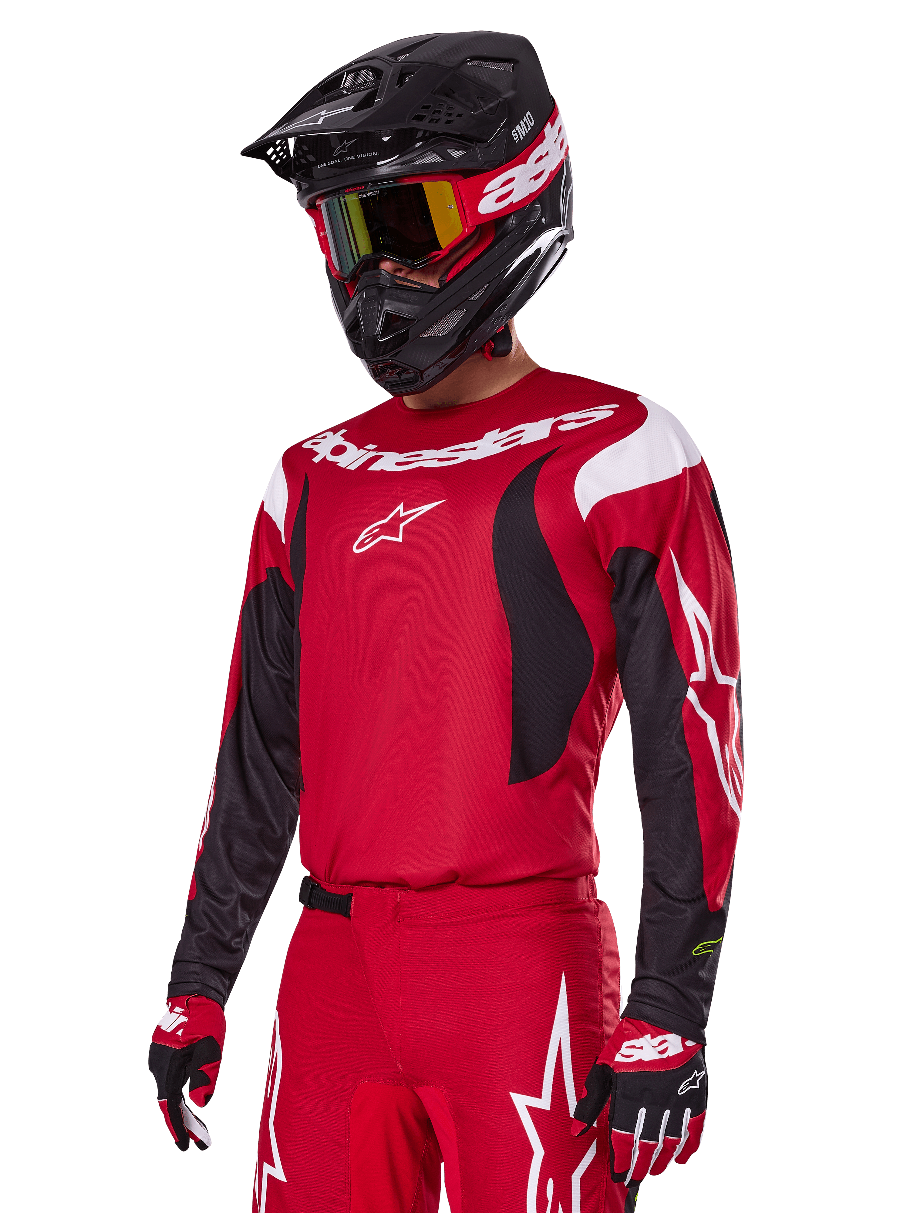 Pilote de motocross portant l'ensemble d'équipement Alpinestars 2025 Fluid Haul rouge, comprenant un maillot rouge avec des accents blancs et noirs, un pantalon rouge assorti avec des graphismes blancs, un casque noir avec logo blanc, des lunettes rouges et jaunes et des gants rouges et noirs, tenue de course de motocross coordonnée