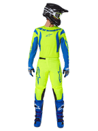 Alpinestars 2025 Fluid Haul Gear Set, motorcross jersey en broek, fluogeel en blauw, gedragen met bijpassende blauwe laarzen en een zwarte helm, met opvallende Astars-logo's en een atletische ergonomische snit voor off-road racen.