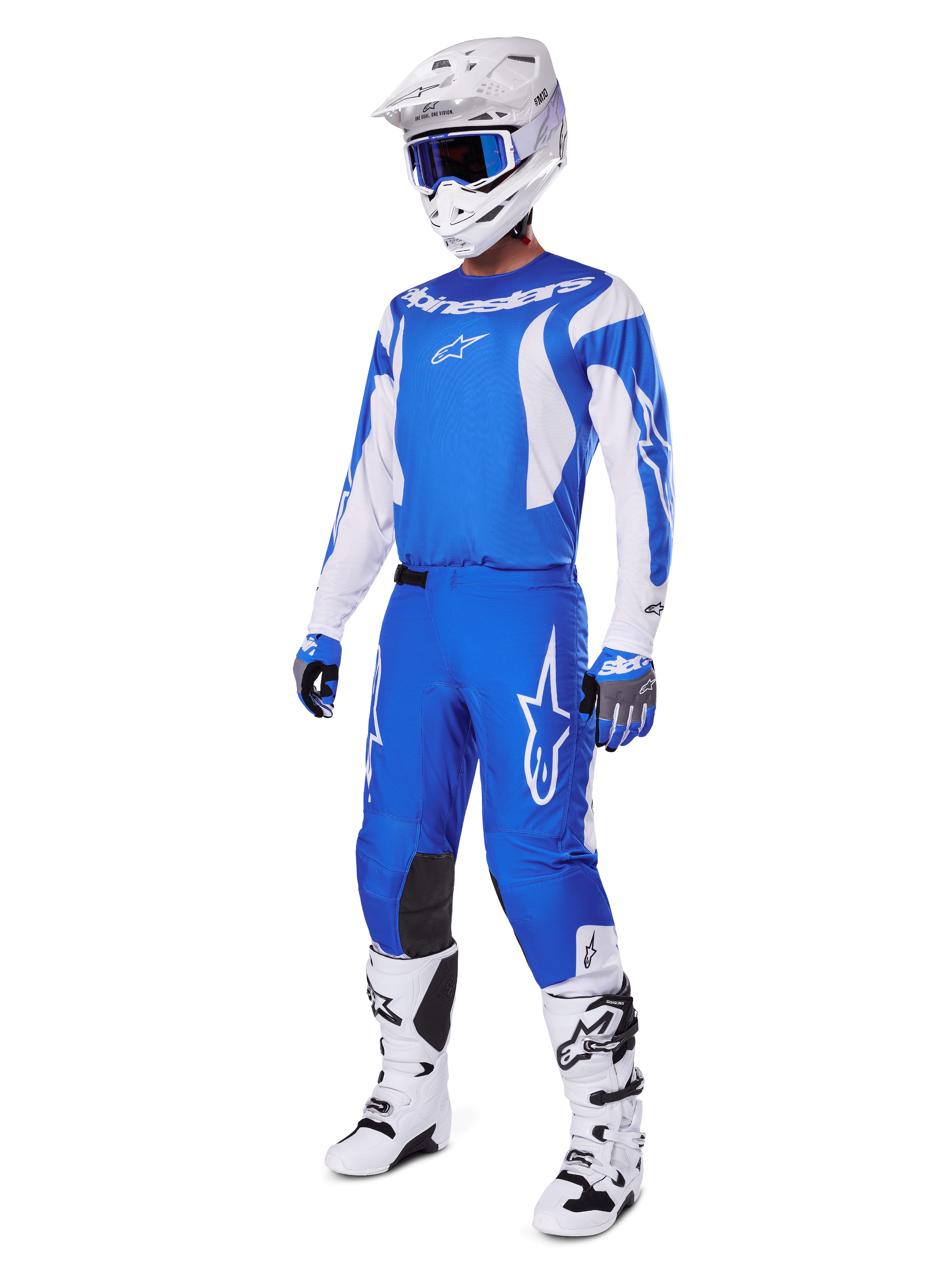 Motocross-Fahrer trägt das komplette 2025 Fluid Haul Gear Set, blau-weißes Trikot und Hose mit Alpinestars-Branding, weißer Helm mit blauer Brille, weiße Stiefel und blaue Handschuhe, koordiniertes Racing-Outfit für Offroad-Motocross.