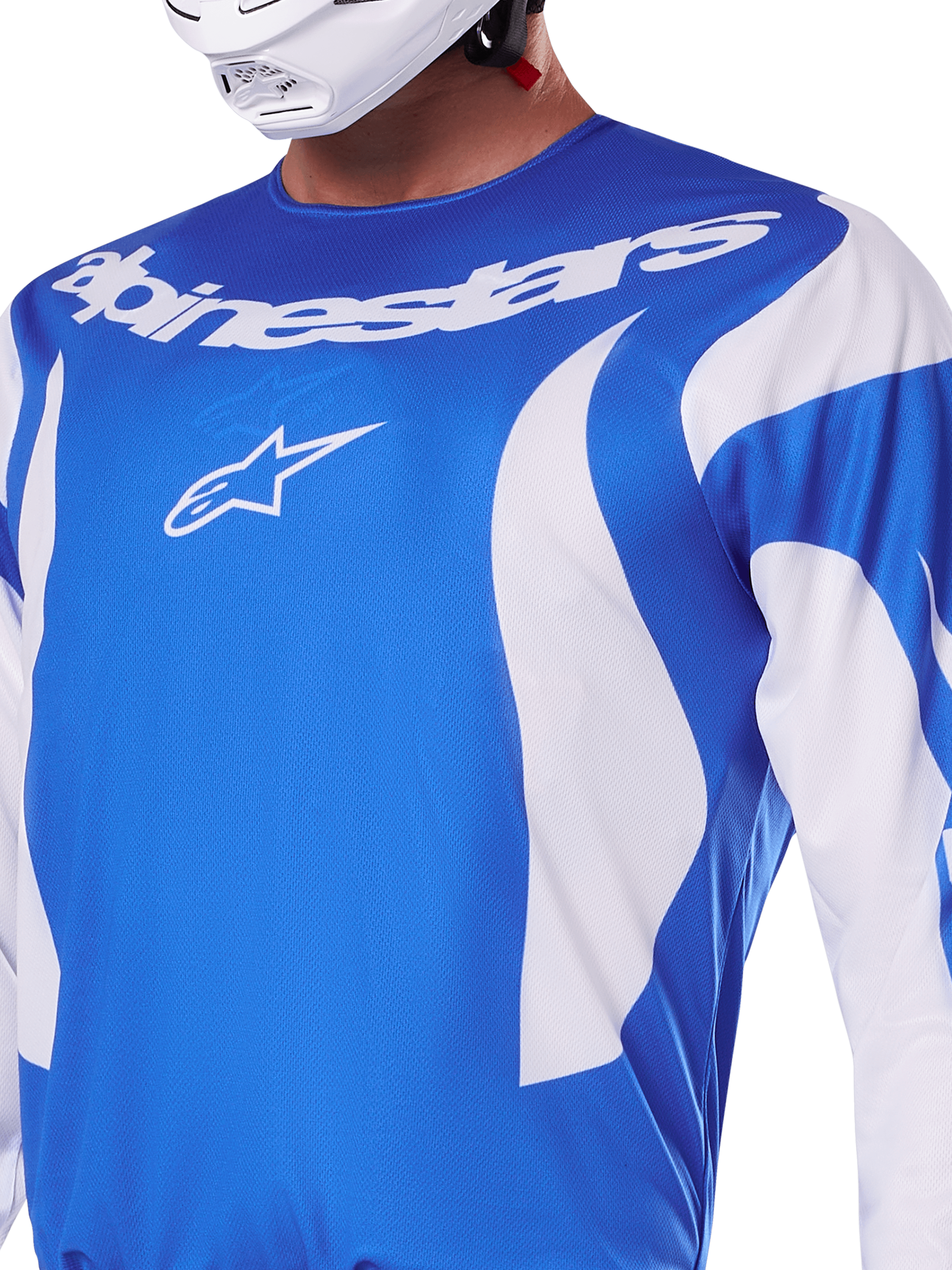 Maillot Alpinestars Fluid Haul 2025, bleu et blanc, porté par un pilote avec un casque blanc, avec lettrage Alpinestars et logo A-star blancs, coupe athlétique, matière légère évacuant l'humidité pour le motocross et le tout-terrain