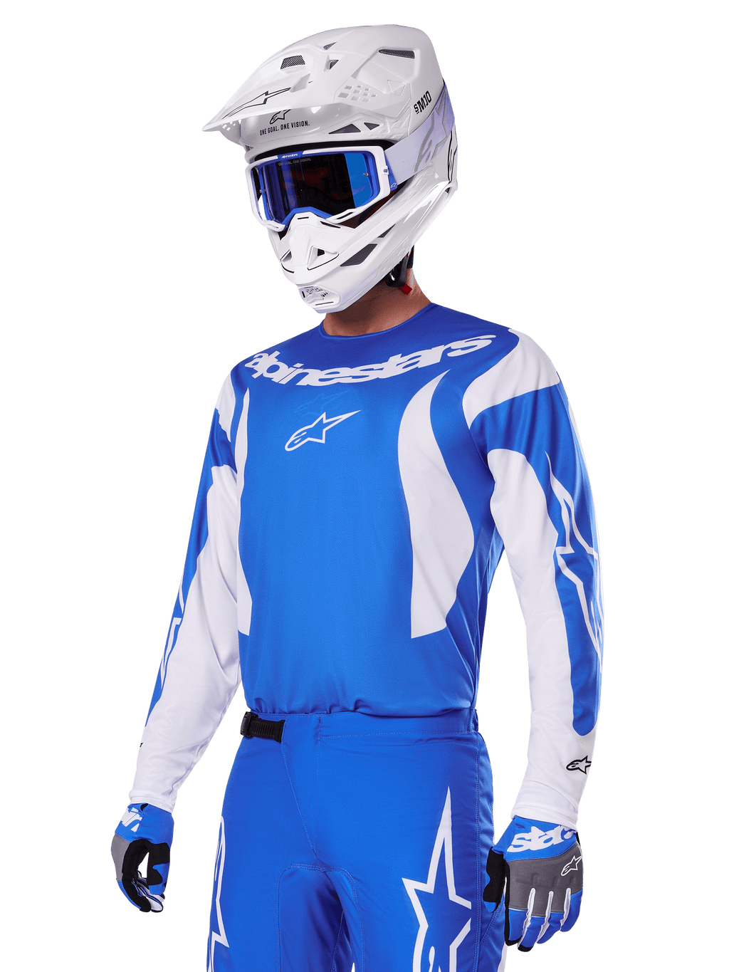 Motorcrosser draagt de Alpinestars 2025 Fluid Haul Gear Set in blauw en wit, met een blauwe jersey met witte accenten, bijpassende blauwe broek met sterlogo's, een witte helm met blauwe bril en gecoördineerde blauwe en grijze handschoenen, complete off-road race-outfit.