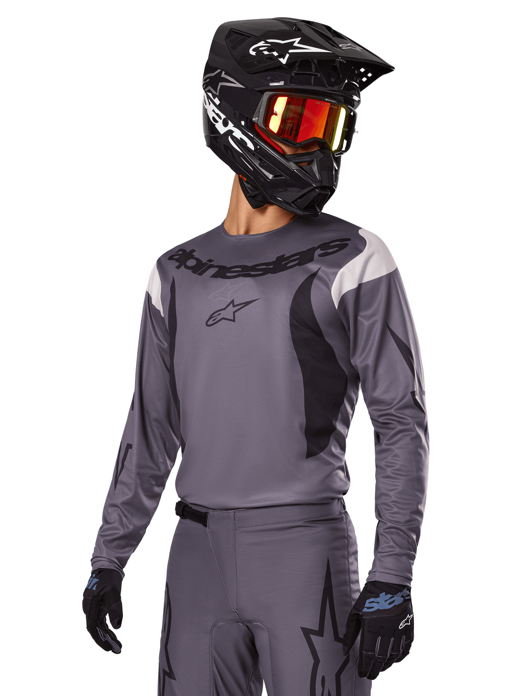 Set d'équipement Alpinestars Fluid Haul 2025, maillot et pantalon de motocross gris avec accents noirs et blancs, porté avec un casque noir, des lunettes rouges et des gants noirs, coupe sportive athlétique pour la conduite tout-terrain