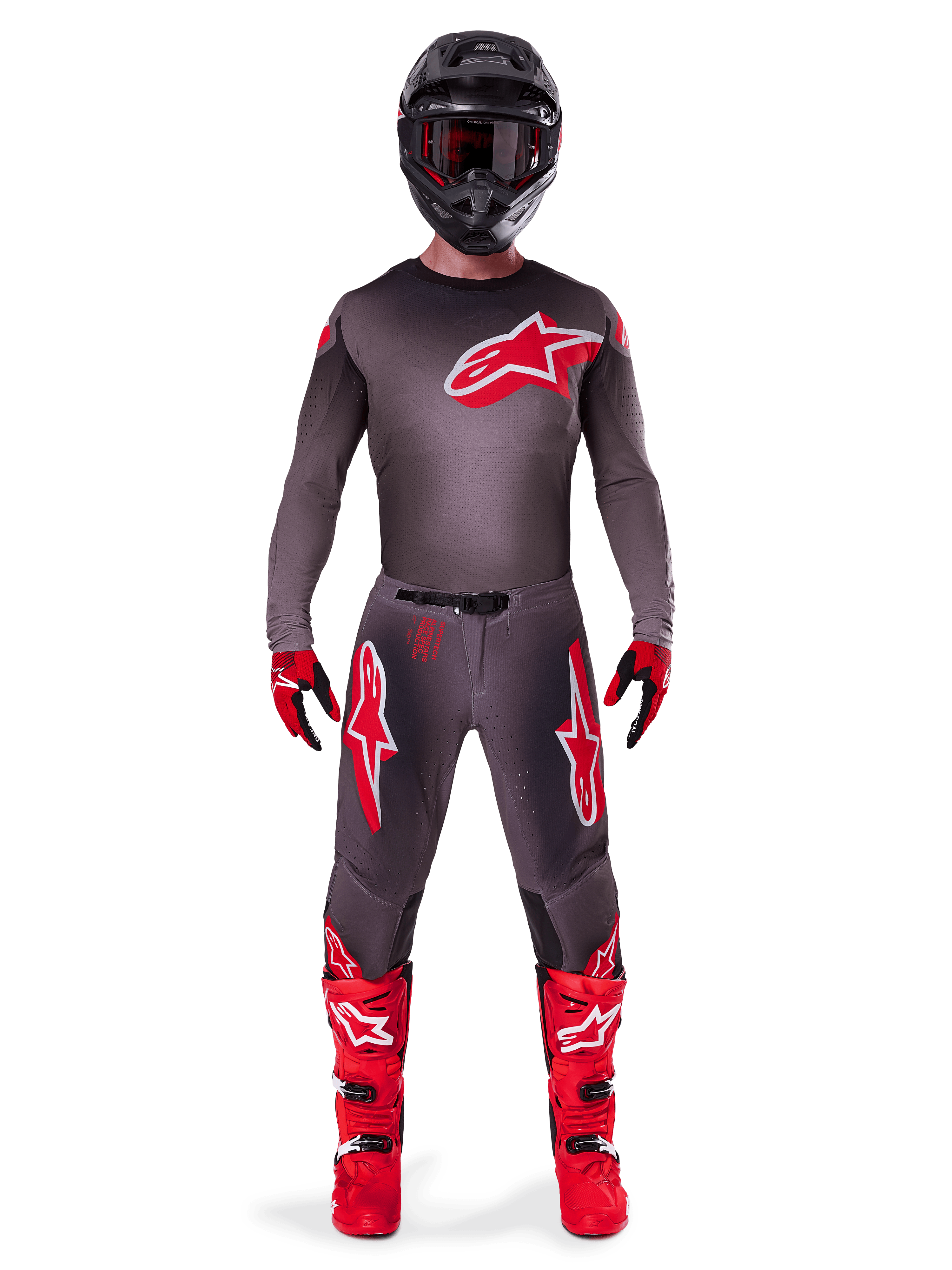 Motocross-Fahrer in kompletter Rennausrüstung, 2025 Supertech Lipan Jersey in Smoke Bright Red, passende graue Hose mit roten Logos, leuchtend rote Stiefel, schwarzer Helm mit Schutzbrille, rot-schwarze Handschuhe, professionelles Motocross-Outfit.