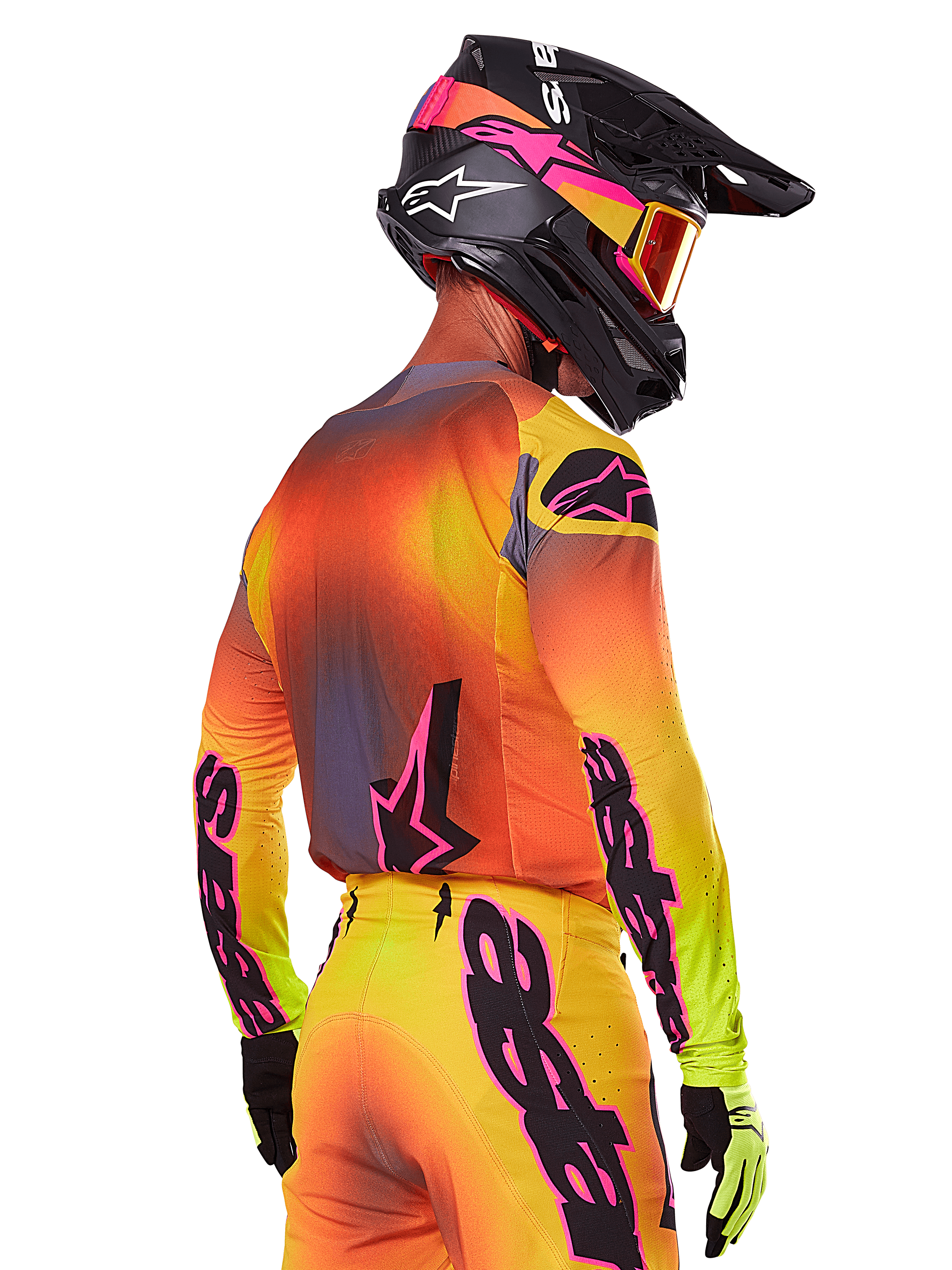 Motocross-Fahrer in der Rückseitenansicht im Alpinestars 2025 Supertech Lipan Gear Set, gelb-orange-roter Farbverlauf mit schwarzem und pinkem Branding, schwarzer Helm mit pinken Akzenten und oranger Brille, professionelle Offroad-Rennbekleidung.