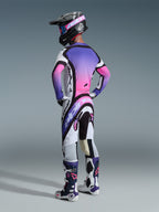 Motocross rider from behind wearing the 2026 Supertech AFD Vista Gear Set in White Purple Black, featuring a jersey with a vibrant purple and pink gradient back panel, matching pants with bold Alpinestars branding, black helmet with pink goggles, and coordinated white and purple racing boots.