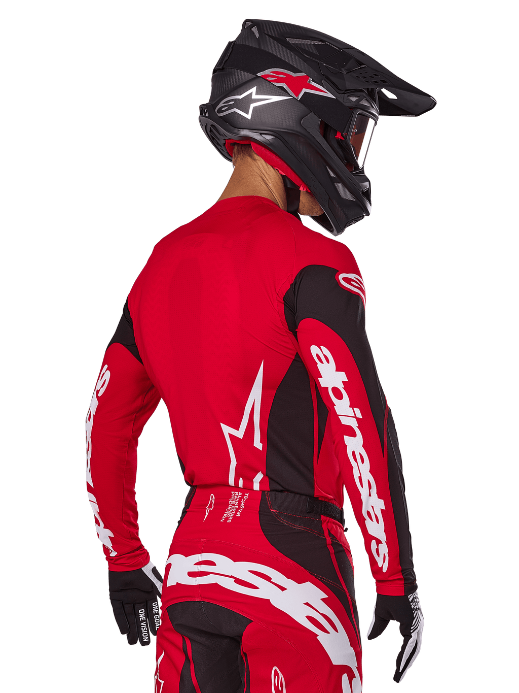 Motocross-Fahrer in der Rückansicht im Alpinestars 2025 Techstar Dreem Gear Set, rot-schwarzes Jersey mit weißem Branding an den Ärmeln, passende rot-schwarze Hose mit markantem weißem Logo auf dem Gesäß, schwarzer Carbon-Helm mit roten Akzenten, schwarz-weiße Handschuhe, professionelles Offroad-Rennoutfit.