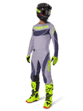 Alpinestars 2025 Techstar Dreem Gear Set, Motocross-Fahrer in kompletter Rennausrüstung, graues Jersey und Hose mit dunkelgrauen Mustern und neongelb-grünen Akzenten, passender schwarzer Helm, neongelb-grüne Handschuhe und Stiefel, Performance-Offroad-Ausrüstung