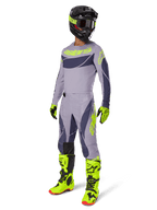 Motocross-Fahrer im 2025 Techstar Dreem Trikot in Grau und Dunkelgrau mit neongelben Akzenten, komplette Rennausrüstung mit passender grauer Hose, neongelben Stiefeln und Handschuhen sowie schwarzem Helm, abgestimmtes Offroad-Performance-Outfit