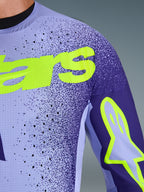Alpinestars 2026 Supertech Scenz Jersey, Motocross-Trikot, Lila und Gelb Fluo, Nahaufnahme mit perforiertem Stretch-Mesh-Material und leuchtend gelbem Alpinestars-Branding auf der Brust und am Ärmel