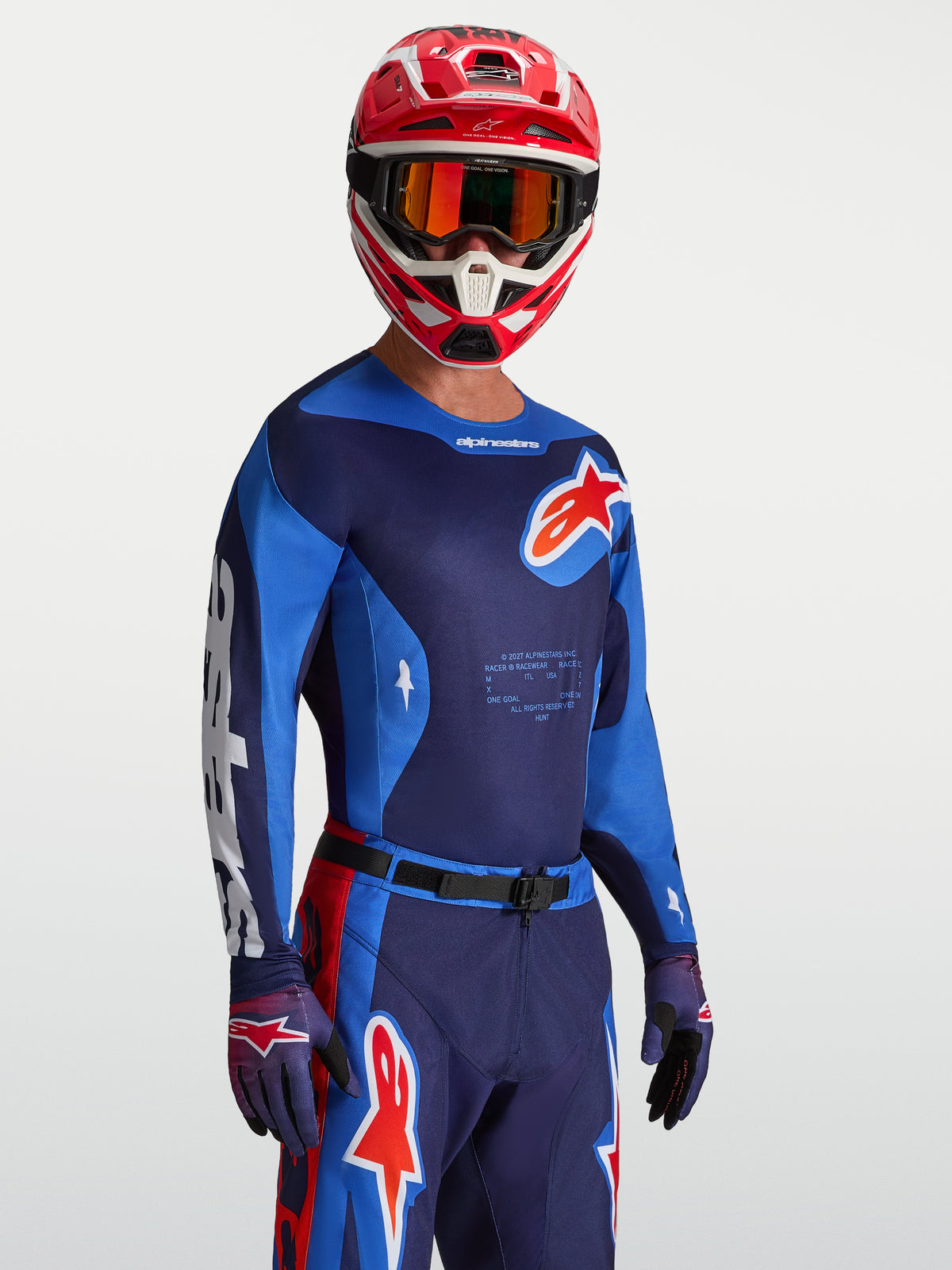 Maillot Alpinestars Racer Hunt, maillot de motocross bleu et rouge, tissu respirant évacuant l'humidité, porté par un mannequin avec casque et gants, équipement de course tout-terrain