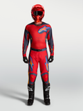Alpinestars Racer Hunt uitrustingsset en broek, heren motocrossoutfit in rood en grijs met helm en zwarte motorlaarzen.