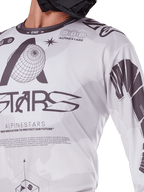 Close-up of Alpinestars 2025 Racer Hollow Jersey, White and Grey, featuring black graphic prints with globe logo and binary code, technical motocross apparel for off-road riding