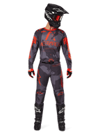 Alpinestars 2025 Racer Hollow Jersey en bijpassende broek in Gray Camo Orange Fluo, complete motorcross outfit met zwarte helm, bril, handschoenen en laarzen, voorzien van opvallende oranje logo's en camouflagepatroon