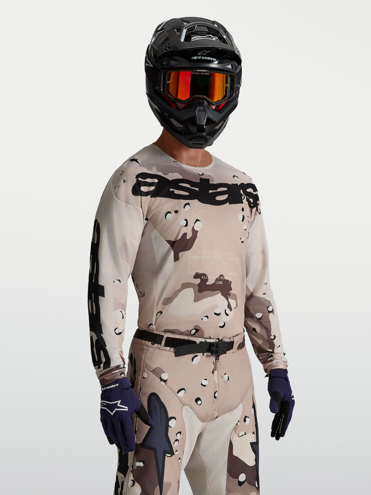 Maillot Racer Lone Alpinestars, maillot de motocross pour homme, camouflage beige et noir, coupe race, porté par un mannequin.