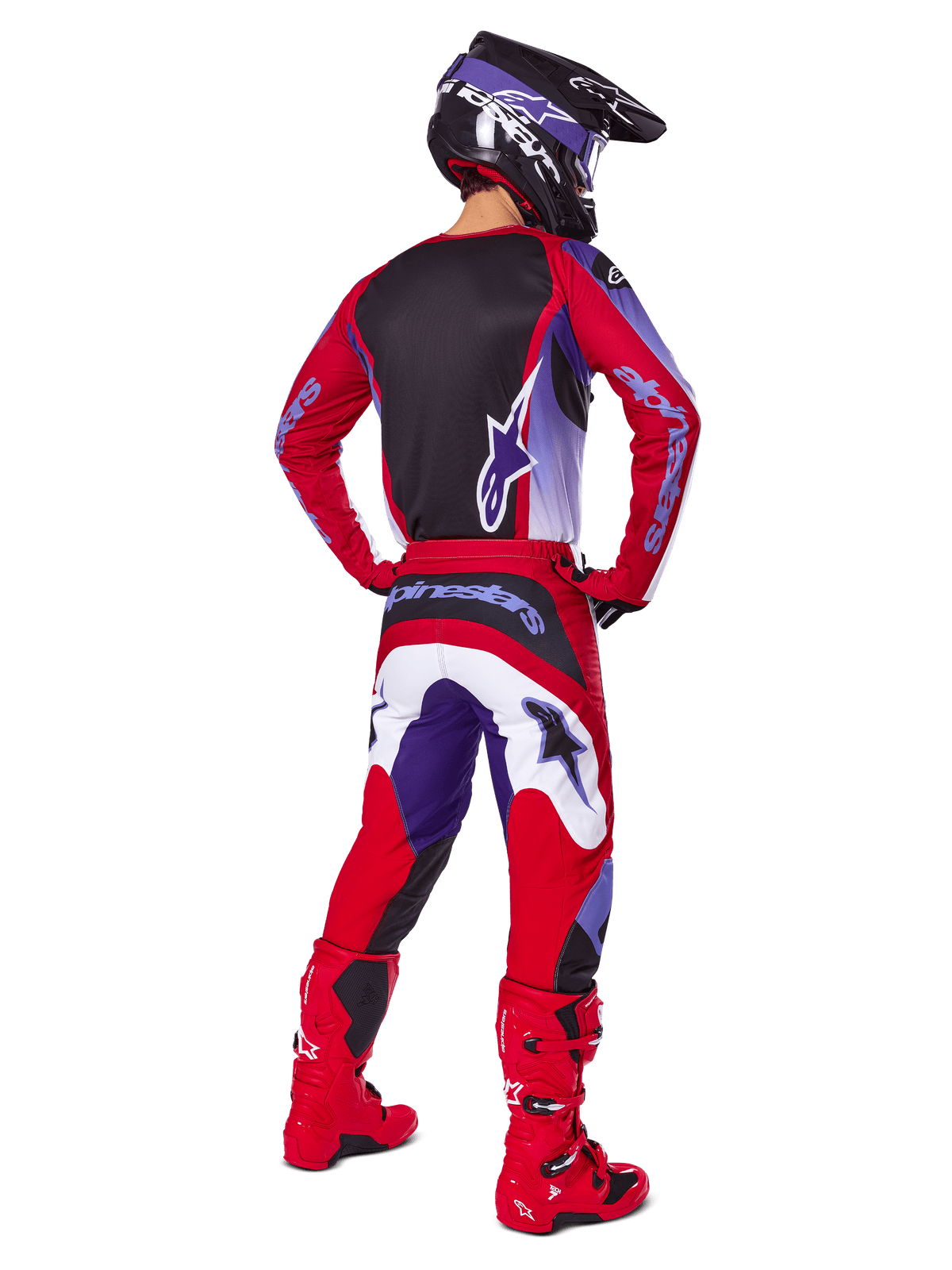 Motorcrosser van achteren gezien in de Alpinestars 2025 Fluid Wurx Gear Set, Purple Bright Red jersey met zwart rugpaneel, bijpassende crossbroek met witte en paarse accenten, felrode laarzen en zwarte helm, professionele off-road race-outfit