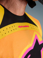 Alpinestars 2026 Techstar Nomur Trikot, Motocross-Trikot, Orange Gelb Pink, Nahaufnahme von Brust und Kragen mit lasergeschnittener Belüftung, pinkfarbenem Branding und atmungsaktivem Mesh-Gewebe