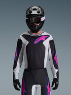 Alpinestars 2026 Fluid Grid Gear Set, Motocross rider wearing a black, white, and pink jersey with matching pants, black helmet with pink and white accents, coordinated professional racing outfit for off-road performance