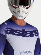 Alpinestars Racer Air Amber Jersey, motocrossjersey voor heren, blauw en wit, meshconstructie met astars-logo, gedragen door model met witte motorcrosshelm.
