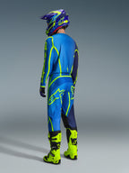 Alpinestars 2026 Fluid Apex Gear Set, Motocross-Fahrer in der Rückansicht mit blau-neongelber Ausrüstung, blaues Jersey und Hose mit neongelben Logos, neongelbe Stiefel, lila-blauer Helm, koordinierte Offroad-Rennbekleidung.