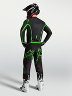 Alpinestars Fluid Apex V2 jersey, zwart en felgroen, achteraanzicht op model met bijpassende motorcrossbroek.