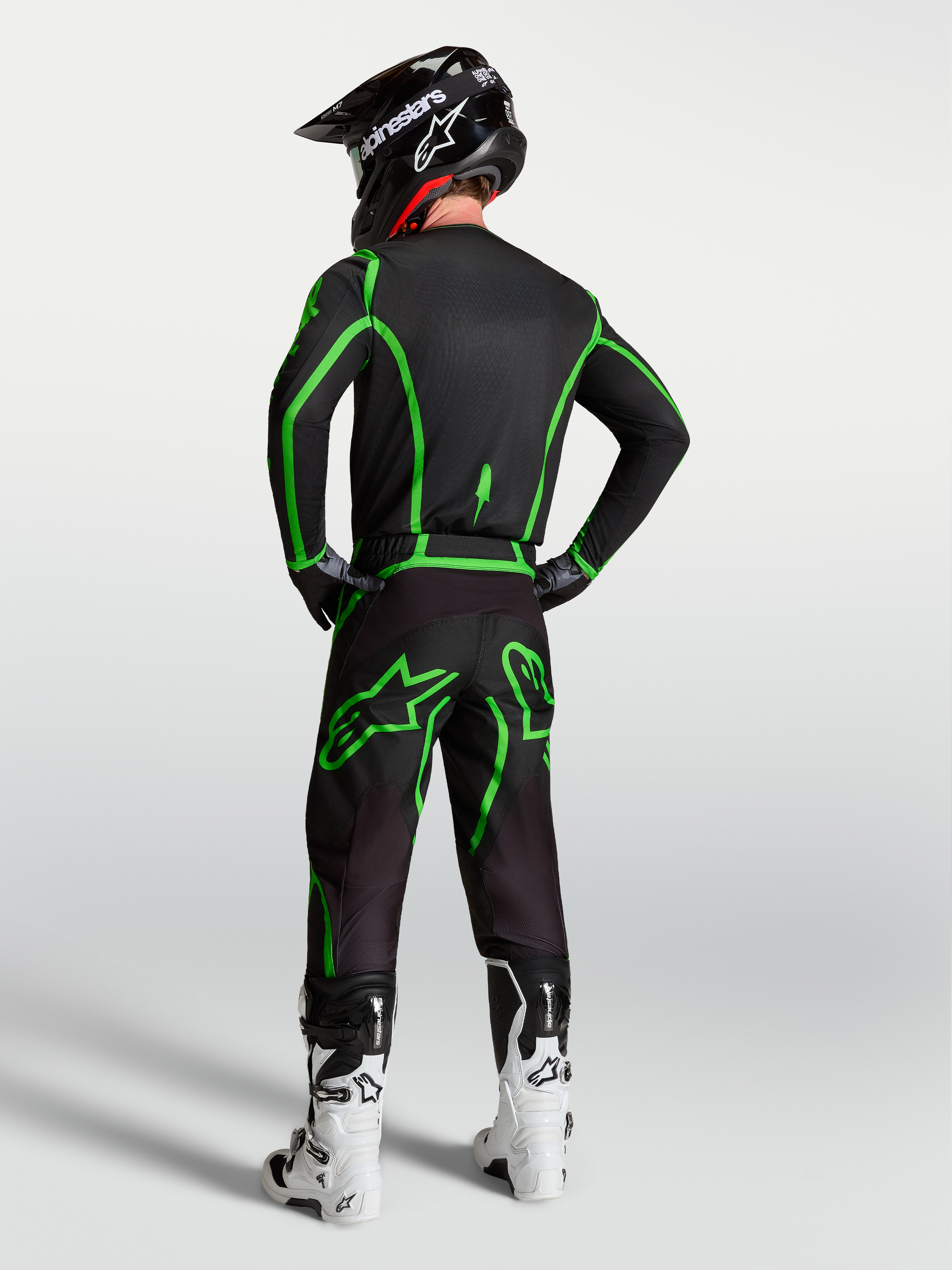 Alpinestars Fluid Apex V2 jersey, zwart en felgroen, achteraanzicht op model met bijpassende motorcrossbroek.