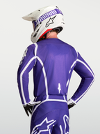 Alpinestars Maillot Fluid Apex V2, maillot de motocross pour homme bleu foncé et blanc, vue de dos sur mannequin avec casque, construction respirante en poly-tissu évacuant l'humidité