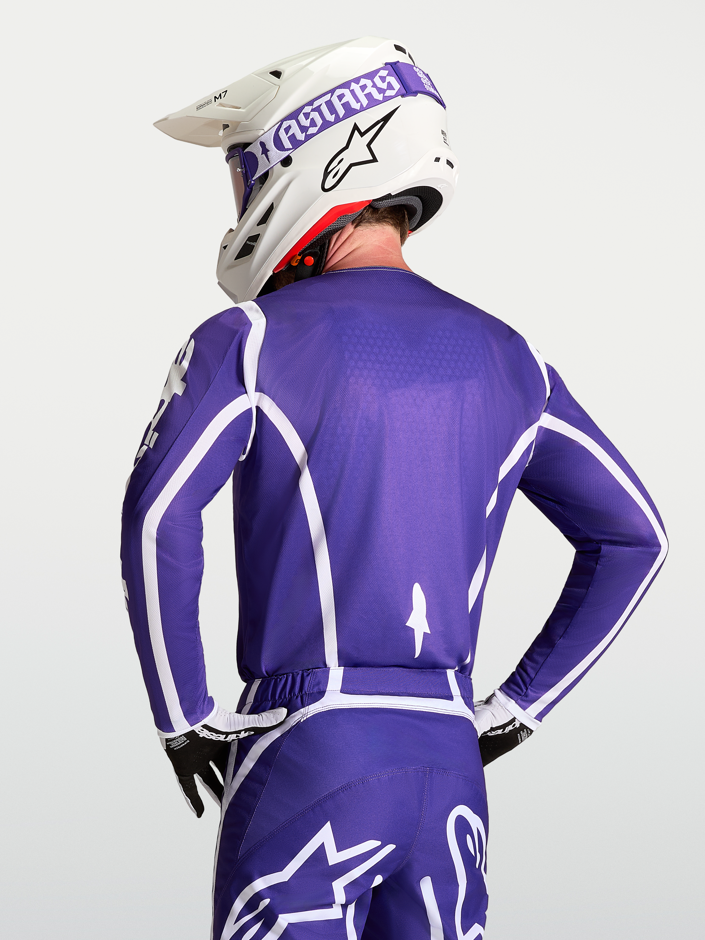 Alpinestars Maillot Fluid Apex V2, maillot de motocross pour homme bleu foncé et blanc, vue de dos sur mannequin avec casque, construction respirante en poly-tissu évacuant l'humidité