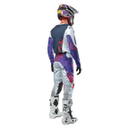 Alpinestars 2024 Racer Hoen Jersey, Motocross-Fahrer von hinten gesehen, Hellgrau, Hot Orange und Schwarz, marineblaues Rückenteil mit orangefarbenem Stern-Logo, lila Ärmel, kombiniert mit passender Rennhose und weißen Stiefeln.