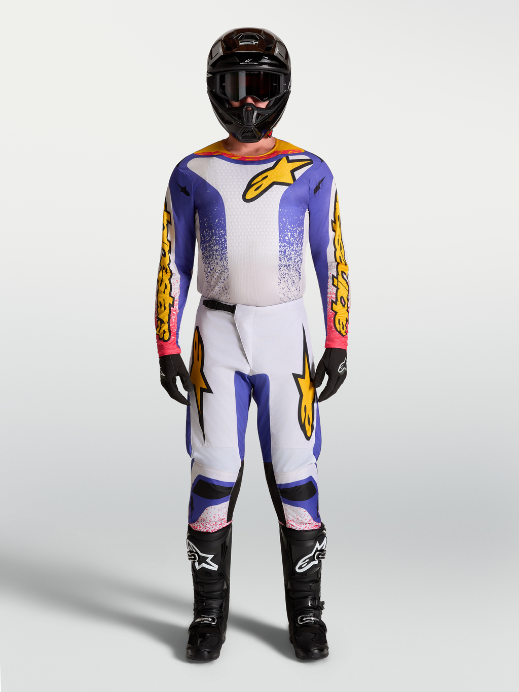 Alpinestars Fluid Drag motocrossset voor heren, lila, blauw en goud, met jersey en broek voor professionele off-road prestaties.