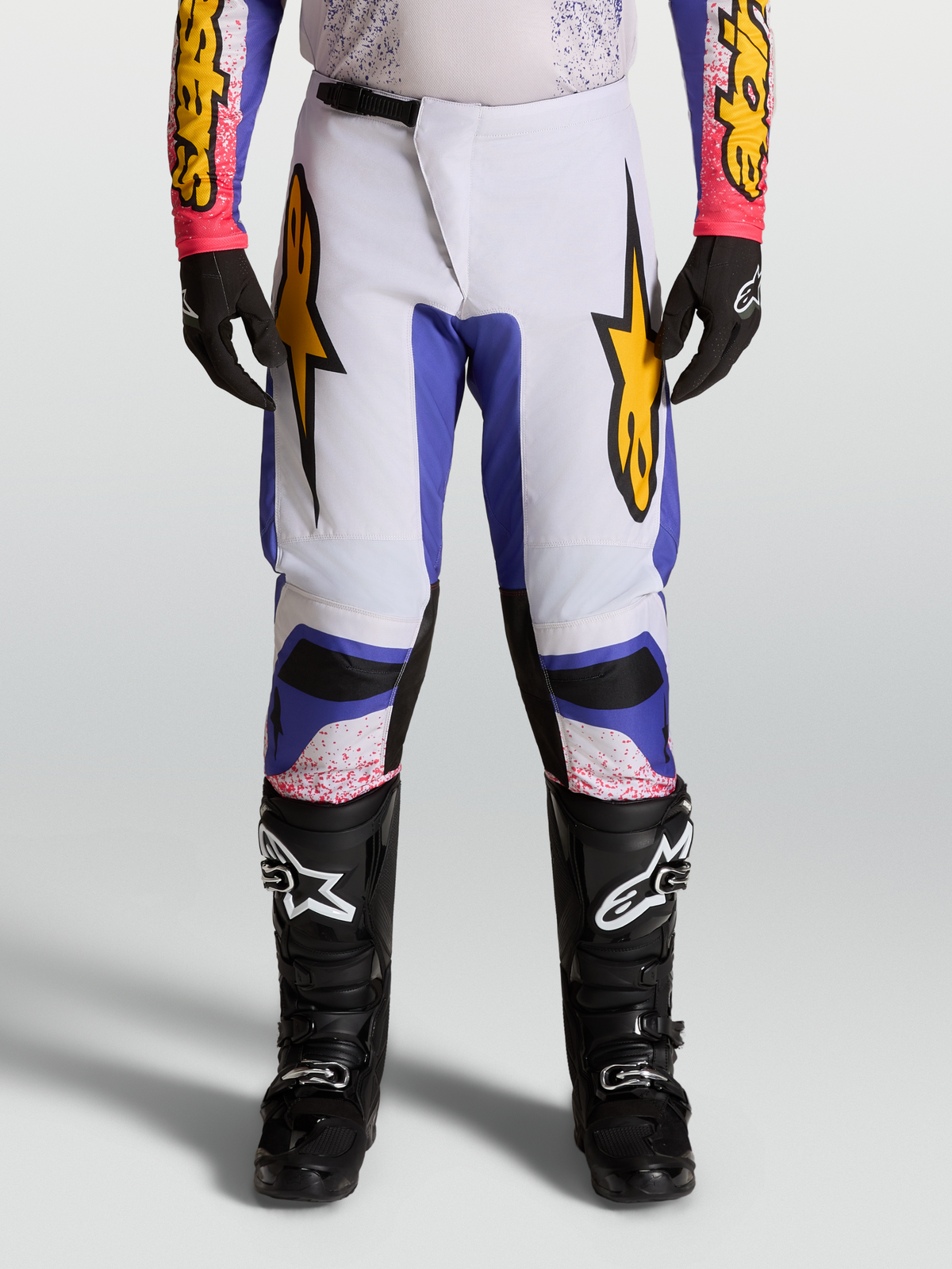 Alpinestars Pantalon Fluid Drag 2027, pantalon de motocross pour homme, lilas clair et bleu iris avec accents dorés.