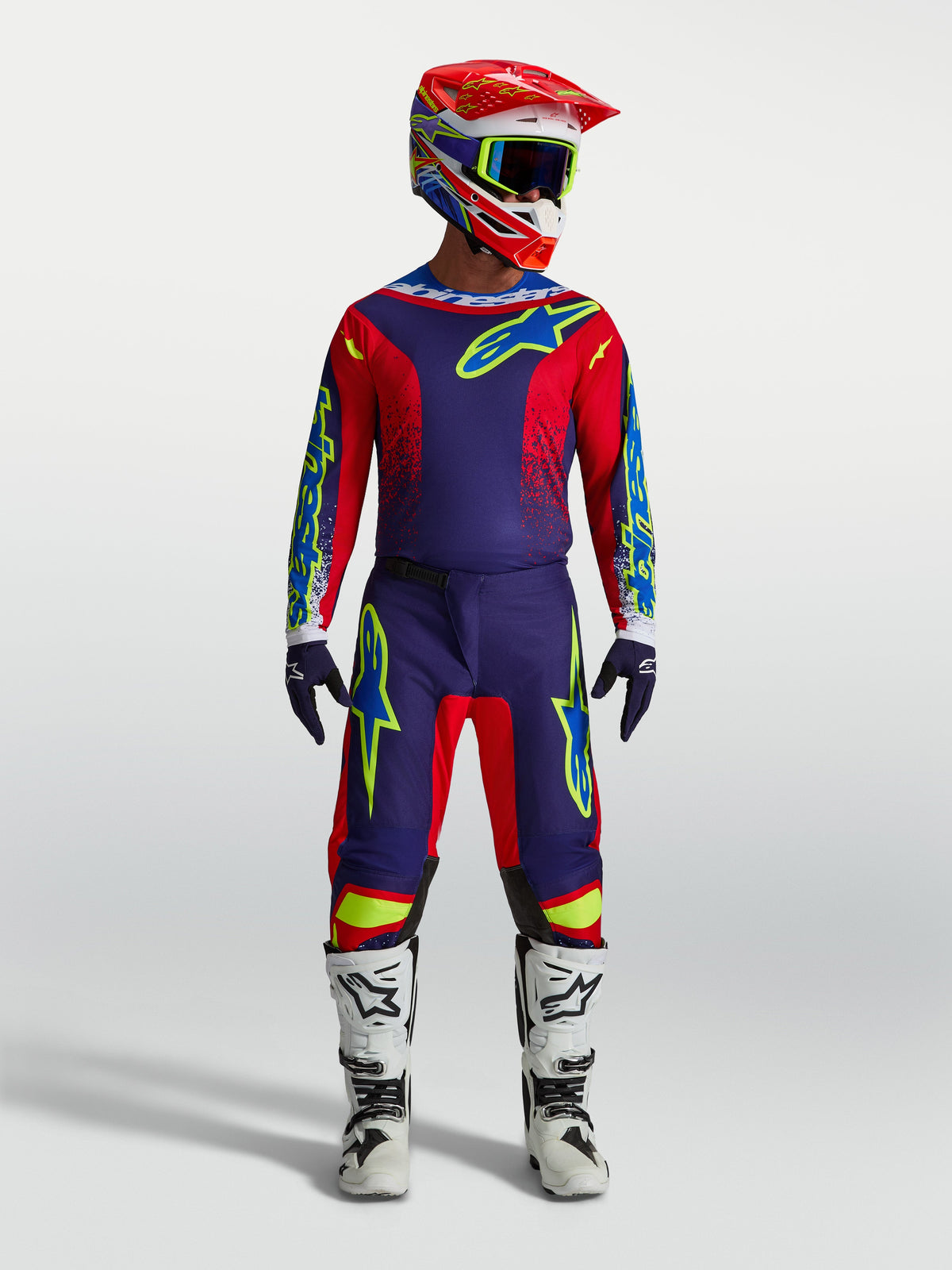 Alpinestars Fluid Drag Jersey en Fluid Drag Gear Set, motocross-uitrusting voor heren, blauw en rood, met witte motorlaarzen en helm, professionele off-road kleding.