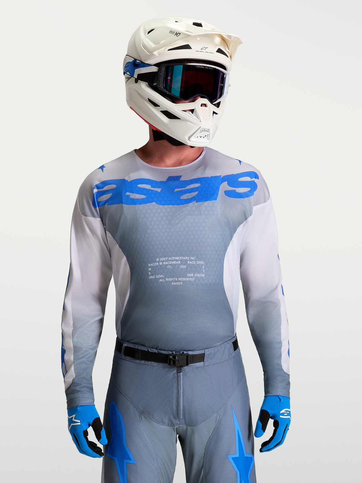 Alpinestars Racer Amber Jersey voor heren, motocrossjersey in grijs en blauw, met witte MX-helm en veiligheidsbril.