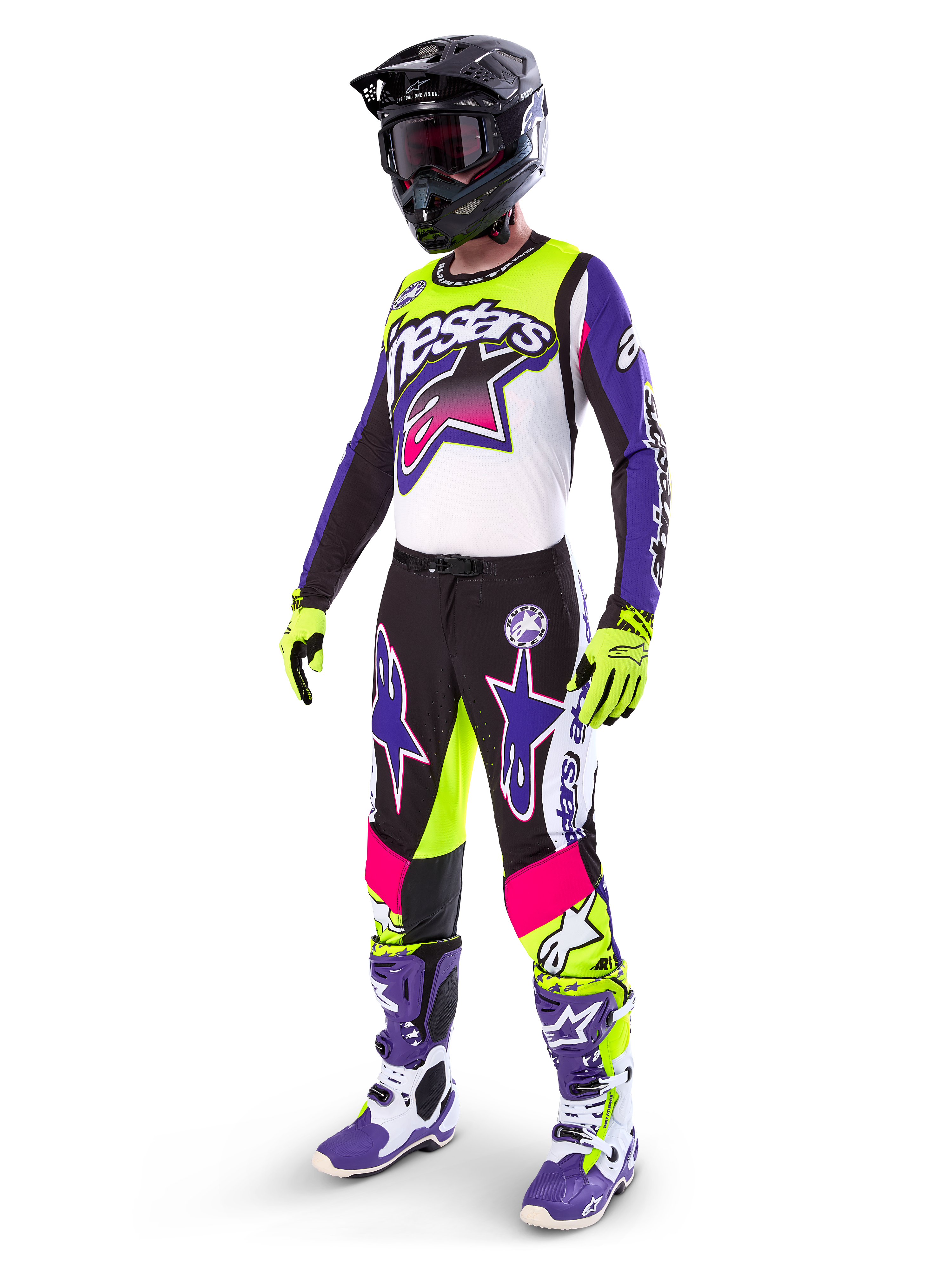 Motocross-Fahrer in Alpinestars Limited Edition Supertech Dirt Studios® Ausrüstung, Farbkombination in Weiß, Lila und Neongelb, schwarze Hose mit auffälligen lila und pinkfarbenen Stern-Logos, neongelbe Handschuhe, lila-weiße Rennstiefel, schwarzer Helm, komplette professionelle Rennausrüstung für Offroad-Performance