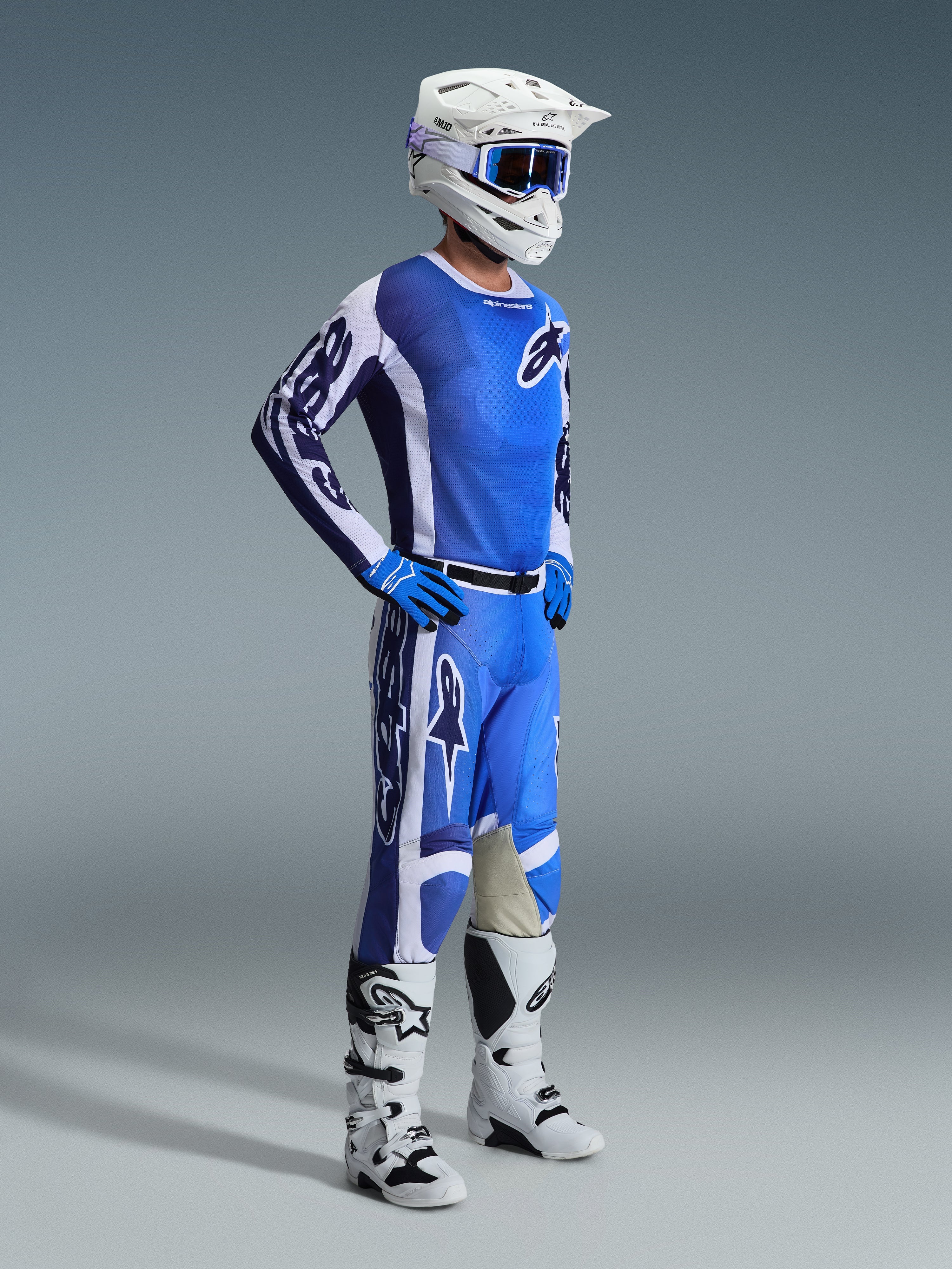 Alpinestars 2026 Racer Air Portl Gear Set, Motocross-Fahrer in kompletter belüfteter Rennausrüstung, blaues und weißes Jersey mit passender Hose, weißer Helm mit blauer Brille, blaue Handschuhe, weiß-schwarze Stiefel, Hochleistungs-Outfit für den Offroad-Einsatz
