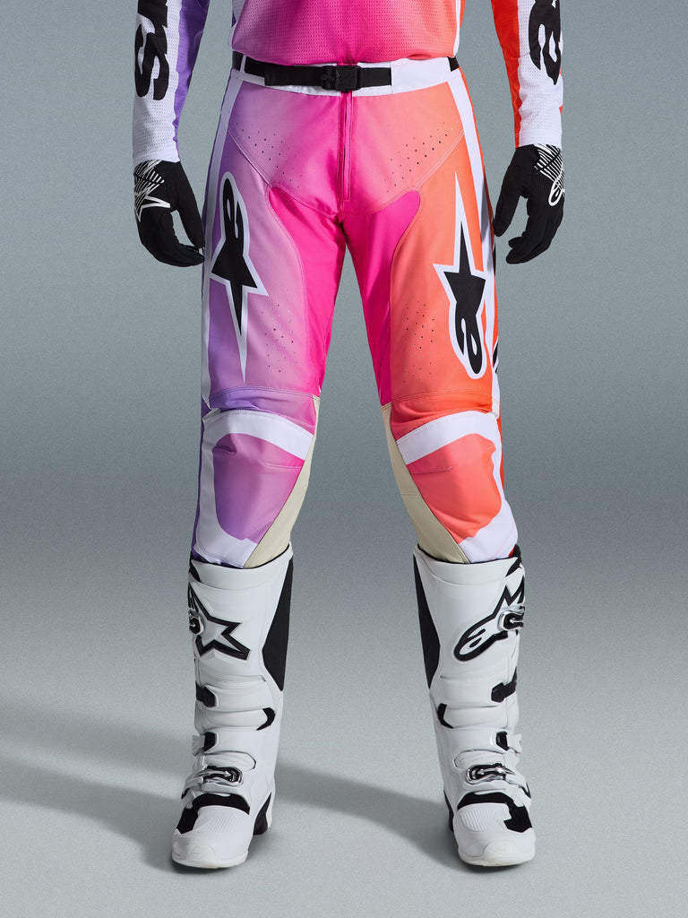 Alpinestars 2026 Racer Air Portl Pants, Motocross Pants, vibrant purple pink and orange gradient, featuring bold star logos on the thighs, worn with white racing boots and black gloves, designed for high-performance off-road riding.