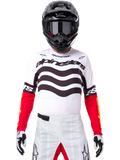 Motocross-Fahrer in kompletter Rennausrüstung, Limited Edition Techstar Deep Trikot in Weiß und Schwarz mit roten Ärmeln, wellenförmige Grafiken und markantes Alpinestars-Branding, weiße Motocross-Hose, schwarzer Helm und Brille, abgestimmtes Outfit für Offroad-Rennen