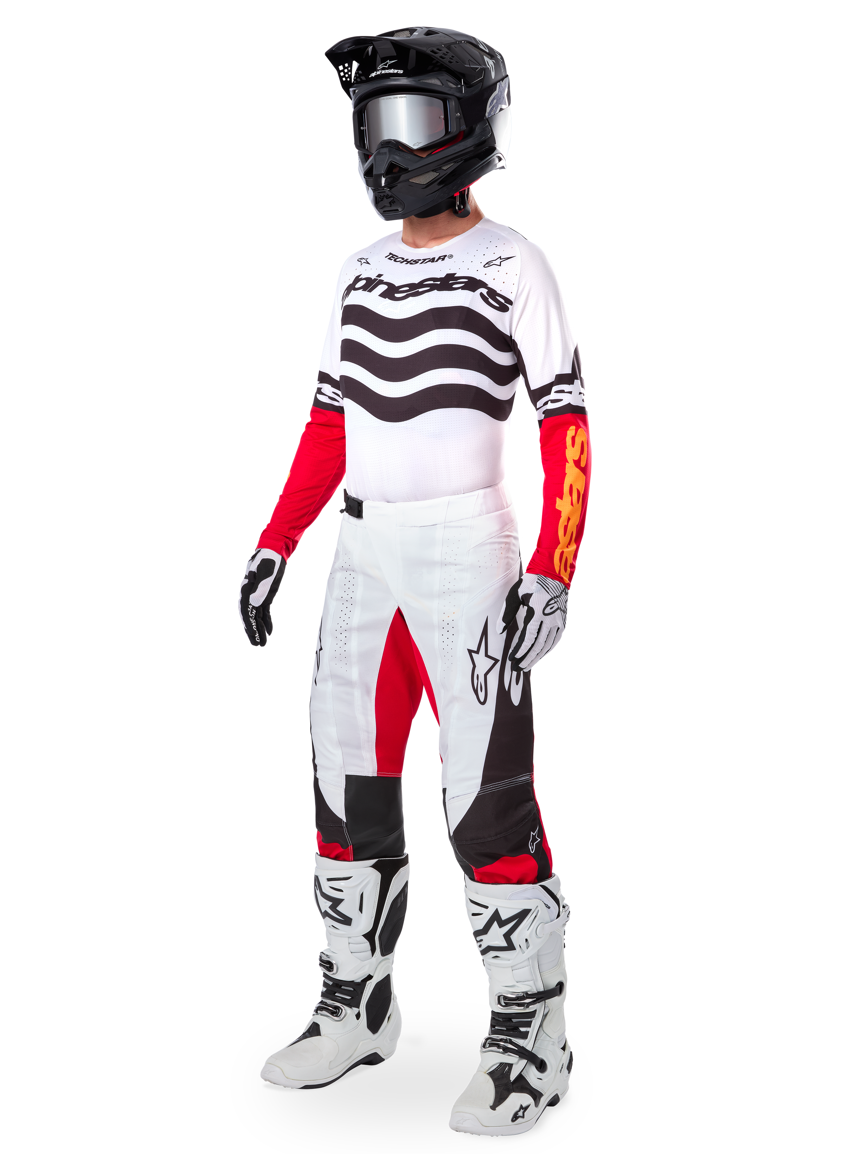 Motocross-Fahrer in kompletter Rennausrüstung, Limited Edition Techstar Deep Jersey mit weiß-schwarzen Wellenstreifen und roten Ärmeln, passender weiß-roter Hose, schwarzem Helm und weiß-schwarzen Stiefeln, koordiniertes Outfit für den Offroad-Rennsport