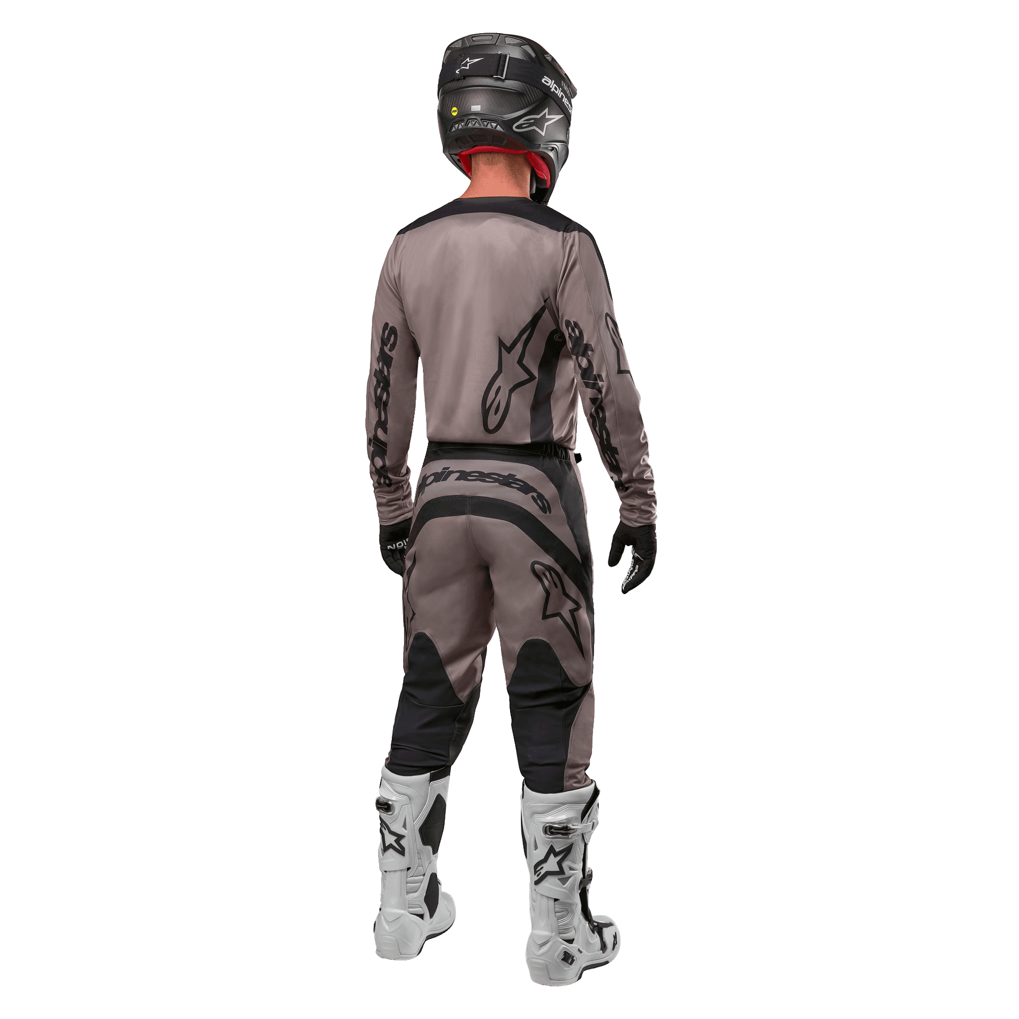 Alpinestars 2024 Fluid Lurv Trikot, Motocross-Trikot, Mud Black, Rückansicht eines Motocross-Fahrers in passender Rennausrüstung, schwarzer Helm und weiße Stiefel, markante schwarze Alpinestars-Logos, sportliche Passform für Offroad-Performance.