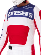Alpinestars Limited Edition Techstar Fortitude Ausrüstungsset, Motocross-Trikot und -Hose in Rot, Weiß und Blau, weißes Trikot mit dunkelblauem oberen Bereich und großer roter Grafik, passende weiß-rote Hose mit SX2-Magnetschnalle, athletische Passform mit lasergeschnittenen Perforationen für Offroad-Rennsport